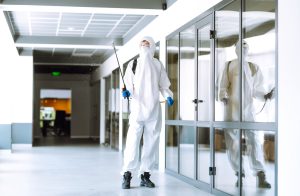 Commercial pest control specialist inspecting and treating an office workspace